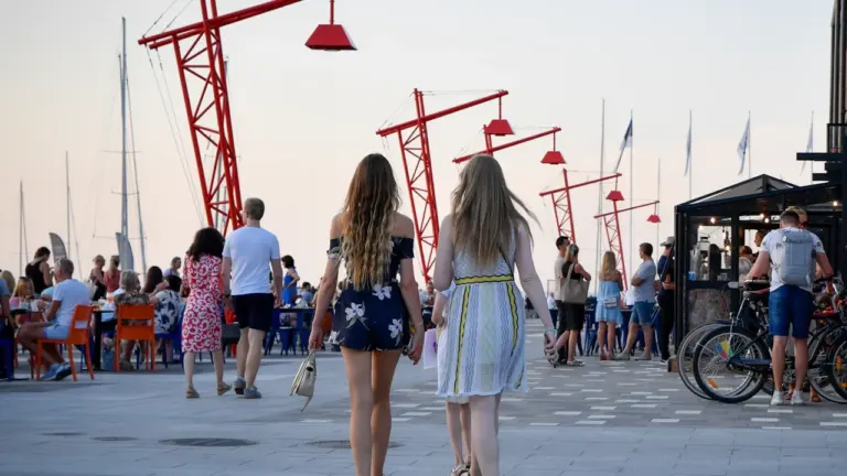 Kaks naist jalutamas suvisel ajal Tallinna Noblessneri sadamalinnaku promenaadil.