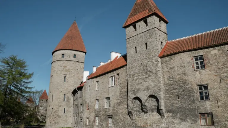 Tallinna vanalinna keskaegne linnamüür ja kivist kaitsetornid selge sinise taeva all.