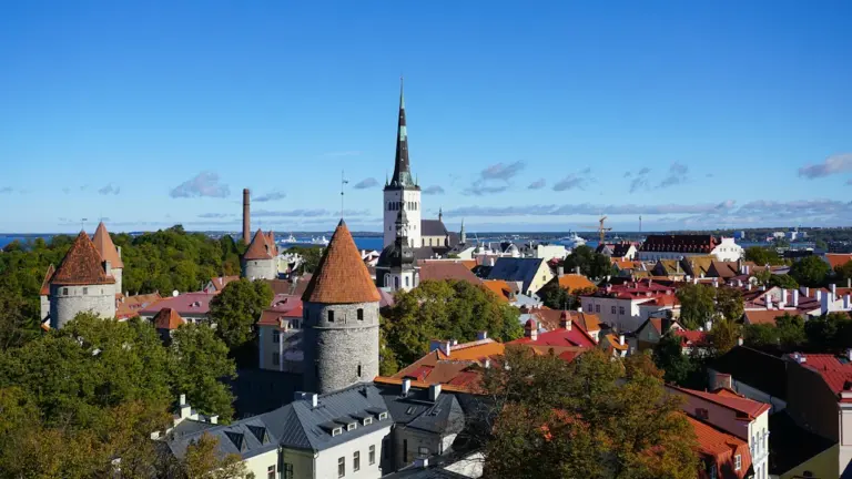 Panoraamvaade Tallinna vanalinna keskaegsetele tornidele ja punastele katustele selge sinise taeva all.