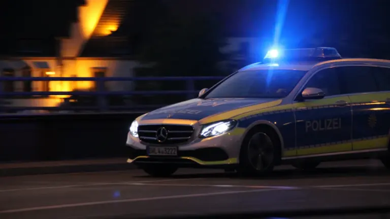 Politsei patrullauto sõitmas pimedal maanteel sisselülitatud siniste vilkuritega, illustreerides politsei tööd nädalavahetusel.
