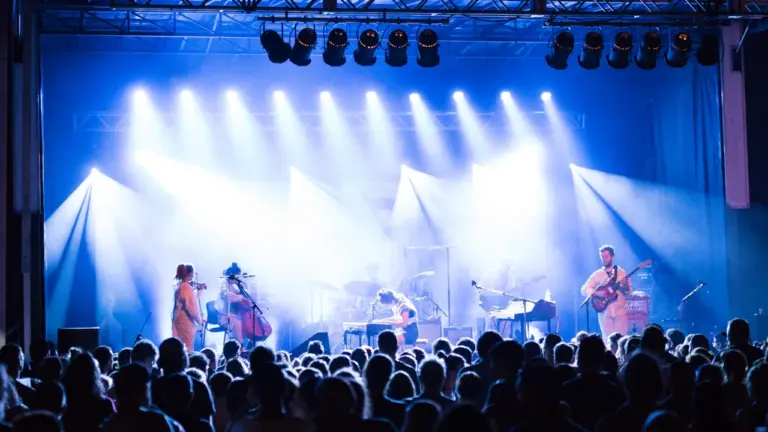 Muusikud esinemas valgustatud laval suure publiku ees suvisel noortepäeva festivalil Saue linnas.