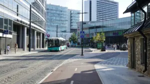 Moodne buss sõitmas mööda Tallinna tänavat, kus on kaasaegne infrastruktuur.