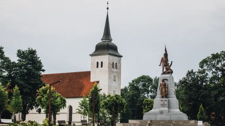 Vana kirikutorn ja Eesti Vabadussõja mälestussammas haljastatud väljakul halli taeva all.