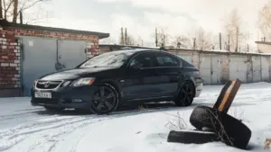 Must auto lumisel parkimisplatsil garaažide ees, viidates vajadusele valmistuda talvisteks teeoludeks.